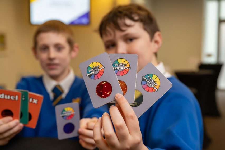 Child holding up colourful playing cards